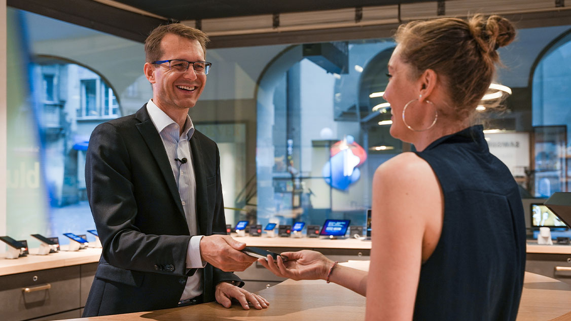 Swisscom CEO Christoph Aeschlimann thanks a customer in the Swisscom Shop Zytglogge in Bern for her contribution to the one million returned mobiles for Mobile Aid.