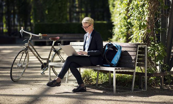 Femme sur banc avec ordinateur portable