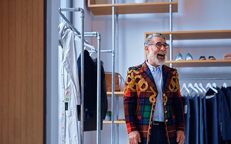 Un homme porte une veste colorée dans un magasin