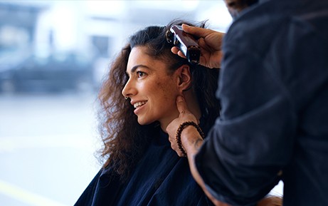 Una donna si fa tagliare i capelli da un parrucchiere