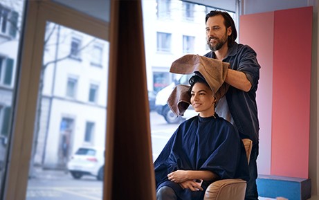 Hairdresser dries a customer's hair